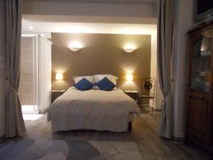 um quarto com uma cama com duas almofadas azuis em Studio des Musiciens - quartier Orangerie em Estrasburgo