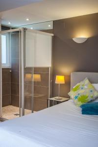 um quarto com uma cama e uma cabina de duche em vidro em Studio des Musiciens - quartier Orangerie em Estrasburgo