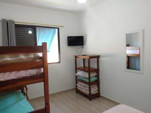 a room with a bunk bed and a television at Recanto Jubarte (Massaguaçu Caraguatatuba - SP) in Caraguatatuba
