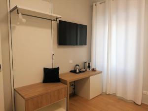 een kamer met een bureau en een televisie aan de muur bij Nike Luxury Rooms in Agrigento