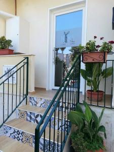 een trap met potplanten en een raam bij Nike Luxury Rooms in Agrigento