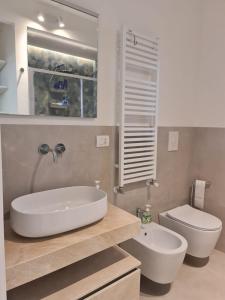 a bathroom with a white sink and a toilet at MYHome Lecce - SalentoSouthApulia in Lecce