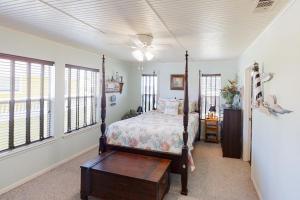 a bedroom with a bed and a ceiling fan at Escape From The Storm in Bolivar Peninsula