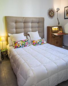 a large white bed with pillows in a bedroom at Villa Schiller, 2 studios côté jardin - quartier Orangerie in Strasbourg