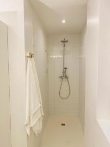 a white bathroom with a shower with a towel at FeWo Silberberg im Loftstil mit Terrasse in Leonberg