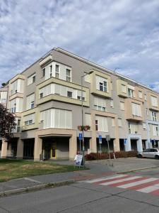 a large apartment building on the corner of a street at Patrik Apartment Šamorín in Šamorín