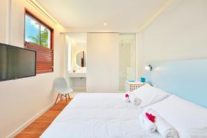 a bedroom with a white bed with two stuffed animals on it at Estalagem Bonfim, 351 in Olinda