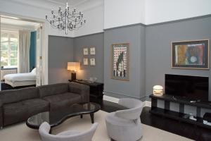 een woonkamer met een bank en een tv bij Appartement Chic in Brussel +15 foto's