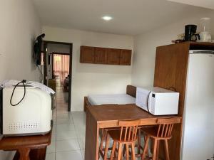 een keuken met een magnetron en een aanrecht met krukken bij FLAT11MODULO18_MONTECASTELO in Bezerros