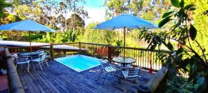 a deck with a pool and tables and chairs and umbrellas at La Martina Campestre in Rionegro