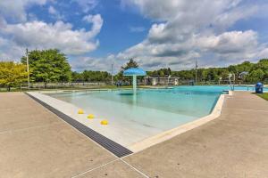 una gran piscina con una sombrilla azul. en Peaceful Pocono Lakefront, beach, pools, firepit, pets, en Arrowhead Lake