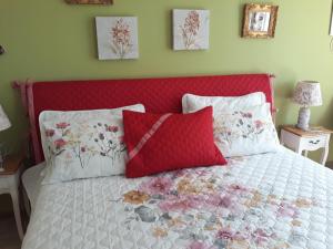 uma cama com cabeceira vermelha e almofadas em Sweet Garden Residence em Brasov