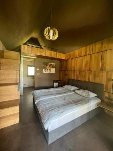 sypialnia z dużym łóżkiem i drewnianą ścianą w obiekcie Ranč Mackadam Ranch Mackadam w mieście Tržič