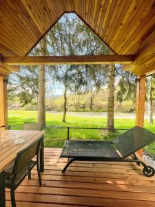 un patio avec une table et un banc sur une terrasse en bois dans l'établissement Ranč Mackadam Ranch Mackadam, à Tržič