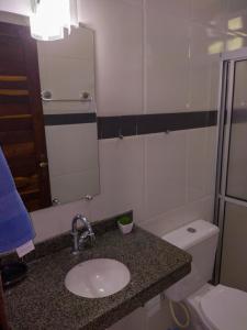 y baño con lavabo, aseo y espejo. en Casa em Morro de São Paulo, en Morro de São Paulo