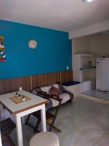 a kitchen with a table and a blue wall at Casa em Morro de São Paulo in Morro de São Paulo