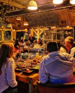 un grupo de personas sentadas en una mesa en un restaurante en Hotel Coandi, en Arad