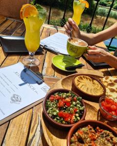una mesa de madera con un plato de comida y bebida en Hotel Coandi en Arad