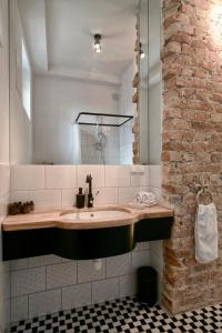 La salle de bains est pourvue d'un lavabo et d'un mur en briques. dans l'établissement Dream Factory Apartment, à Varsovie