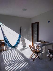 a hammock in a room with a table and chairs at Casa em Morro de São Paulo in Morro de São Paulo