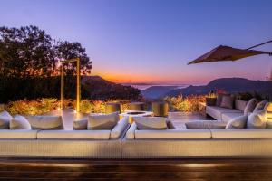 a living room with white couches and a sunset at Chateau Laghetto Collection in Gramado