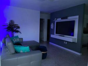 a living room with a couch and a flat screen tv at Stayover In Miami Home 2BR - 1BTH - free parking in Miami