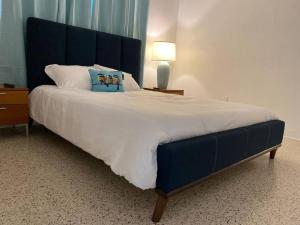 a large bed with a blue headboard in a bedroom at Stayover In Miami Home 2BR - 1BTH - free parking in Miami