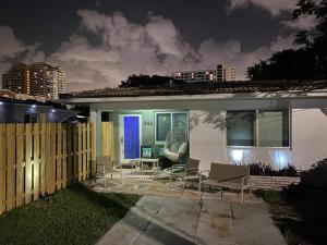 a house with chairs and a blue door at night at Stayover In Miami Home 2BR - 1BTH - free parking in Miami