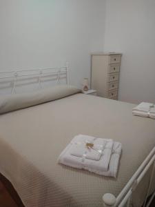 - un lit blanc avec une serviette pliée dans l'établissement Casa Cecilia, à Gallico Marina
