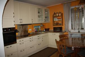 ベンドルフにあるFerienhaus Lilliの白いキャビネットとテーブル付きのキッチンが備わります。