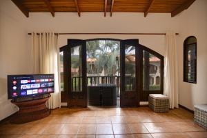 a living room with a large door and a television at Apartotel Girasol in Jacó