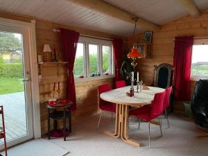 斯萊斯的住宿－Norsk bjælkehytte med fibernet，一间带桌子和红色椅子的用餐室