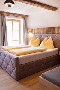 1 dormitorio con 1 cama grande con almohadas amarillas en Lohningbauer, en Maria Alm am Steinernen Meer