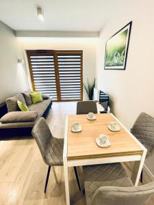 un soggiorno con tavolo, sedie e divano di Modern Silver Apartment a Cracovia