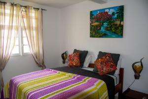 ein Schlafzimmer mit einem Bett und einem Wandgemälde in der Unterkunft Villa Prunepassion in Le Moule