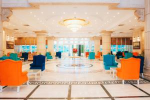 a lobby with orange and blue chairs and a table at Aracan Portsaid in Port Said