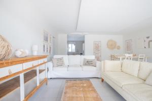 a living room with two white couches and a table at Casa Mat'Yse in La Bruguière