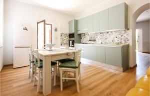 cocina con mesa, sillas y nevera en Stunning Apartment In Santegidio Del M, A, With Kitchen, en Corbara