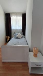 um quarto com uma grande cama branca e uma janela em Apartmani Masline em Jasenice
