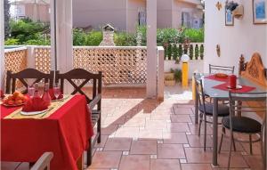 ロハレスにあるNice Home In Rojales With House Sea Viewのパティオ(テーブル2台、椅子、赤いテーブルクロス付)