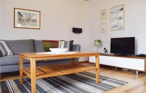 uma sala de estar com um sofá e uma mesa em Stunning Home In Lckeby With Wifi em Ugglerum