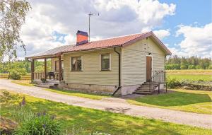 uma pequena casa amarela num campo de relva em Stunning Home In Lckeby With Wifi em Ugglerum