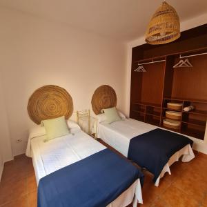 a bedroom with two beds and baskets on the wall at Casa M de mar - Vistas 180º in Corralejo