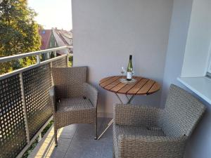 a table with two chairs and a bottle of wine on a balcony at Apartament nad morzem in Gdańsk