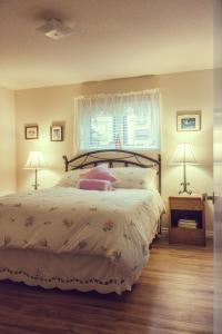 a bedroom with a bed and two lamps and a window at Dave & Honey's Accommodation in Jasper