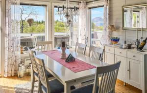 的住宿－Beautiful Home In Hol I Tjeldsund With Wifi，厨房配有桌椅和窗户。