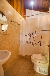 a bathroom with a toilet and a shower curtain with the words get married at Apartotel Girasol in Jacó