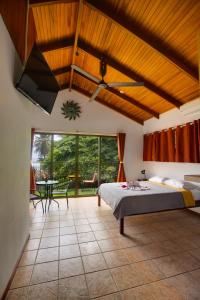 um quarto com uma cama e uma grande janela em Apartotel Girasol em Jacó