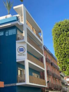 un edificio azul y blanco con un cartel en él en MAR60 Apartments en Caorle