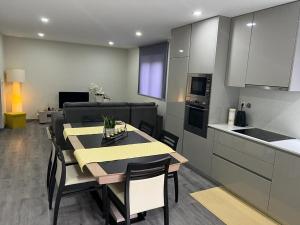 a kitchen and a dining room with a table and chairs at Casa das Flores ll in Paredes de Coura